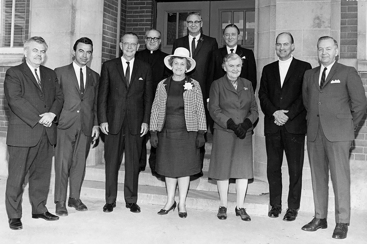 The ten members of Humber's first Board of Governors standing outside a building. 