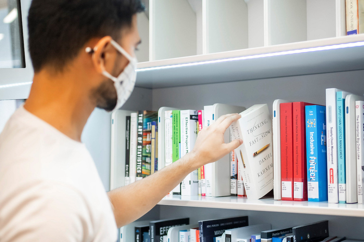 A student selecting a book from the self-serve Book Lending Machine.